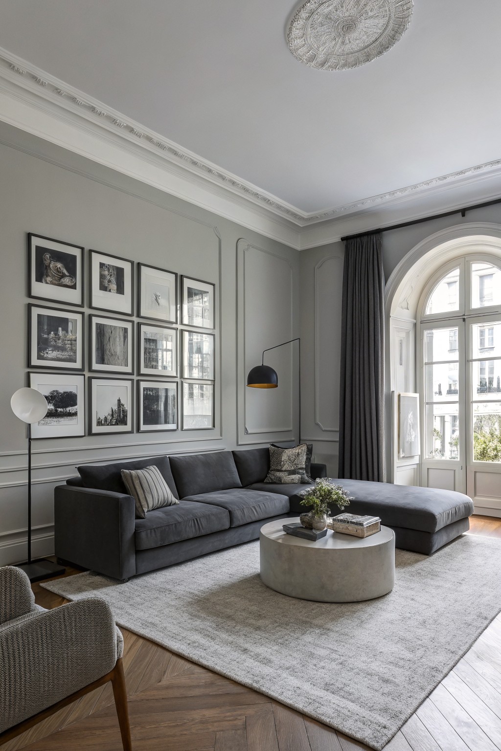 Living room featuring soft greige walls with warm undertones, dark gray sofa, and herringbone wood floors