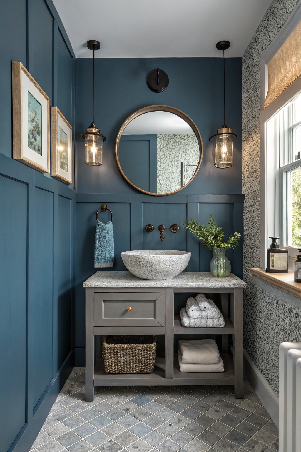 Powder room featuring deep navy blue wainscoted walls, gray wood vanity with white stone vessel sink, gold accents, pendant lights, and window with natural light