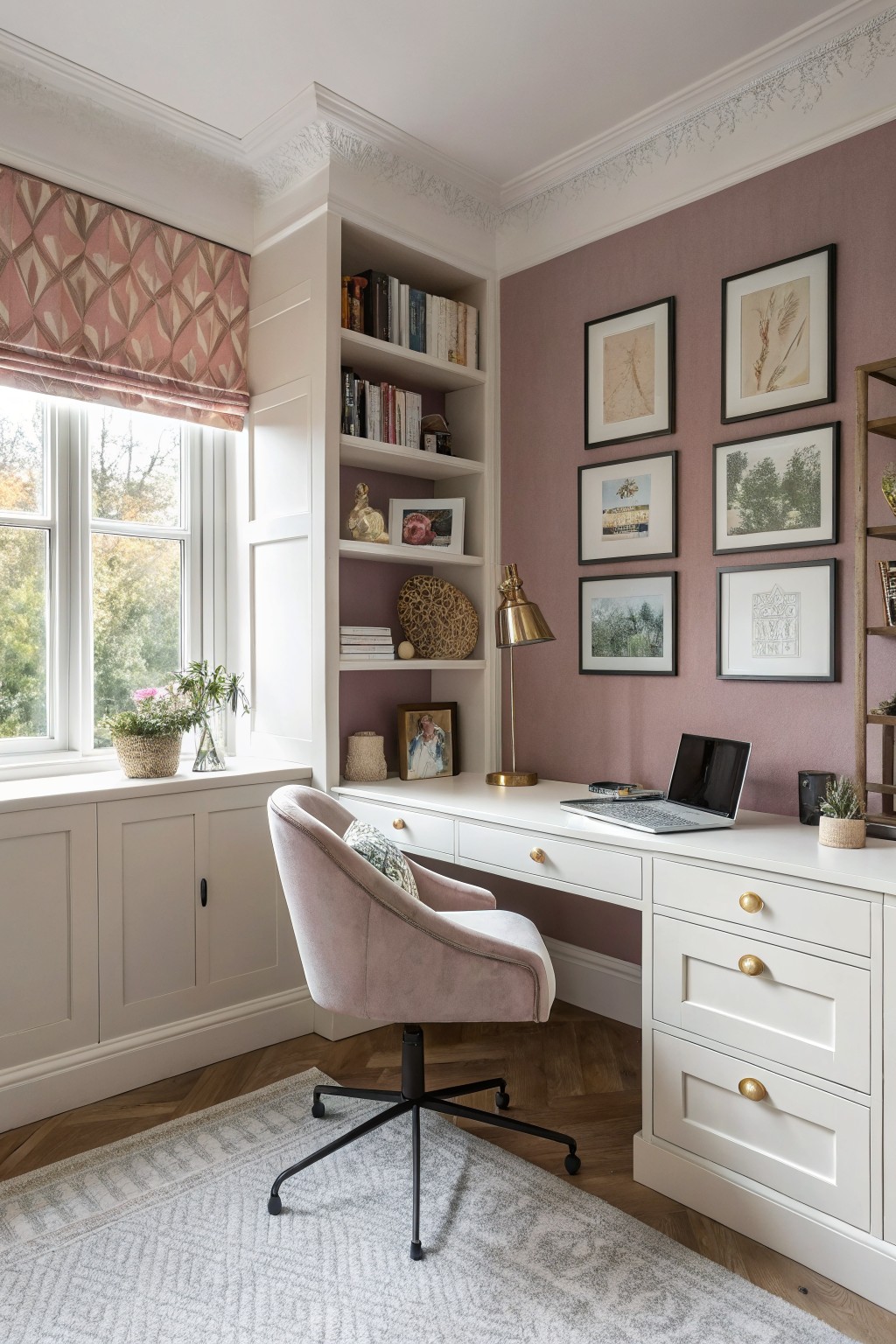 A home office features soft dusty rose walls with white built-in shelves and desk.
