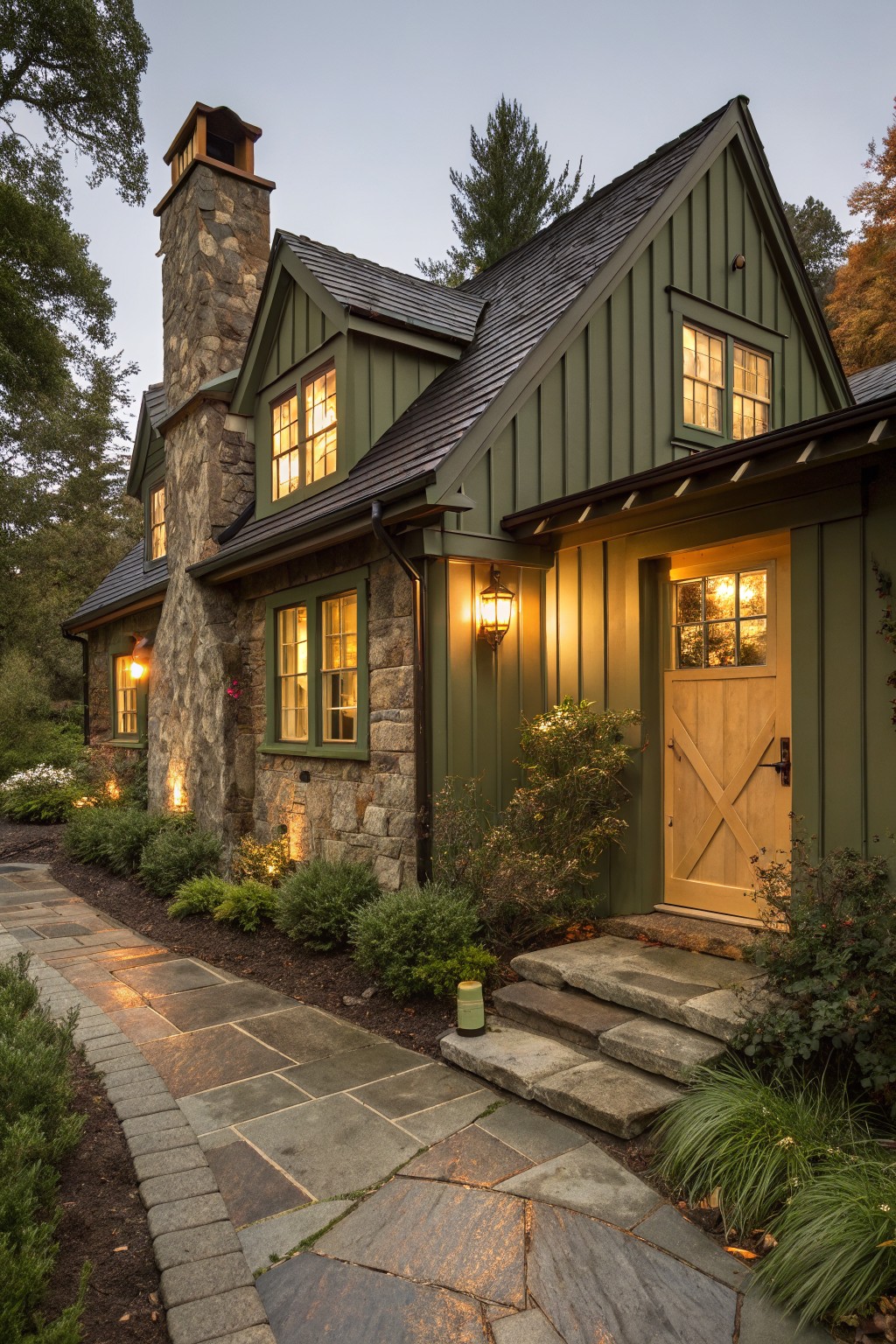 A house exterior with dark green siding next to a stone chimney and black roof.