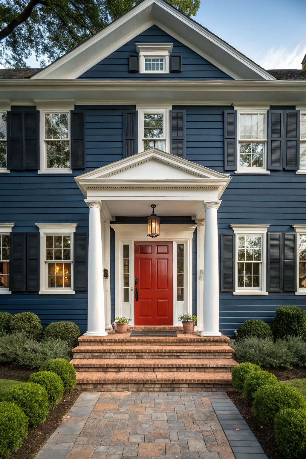 A two-story house with deep navy blue siding and white trim around the front entrance.