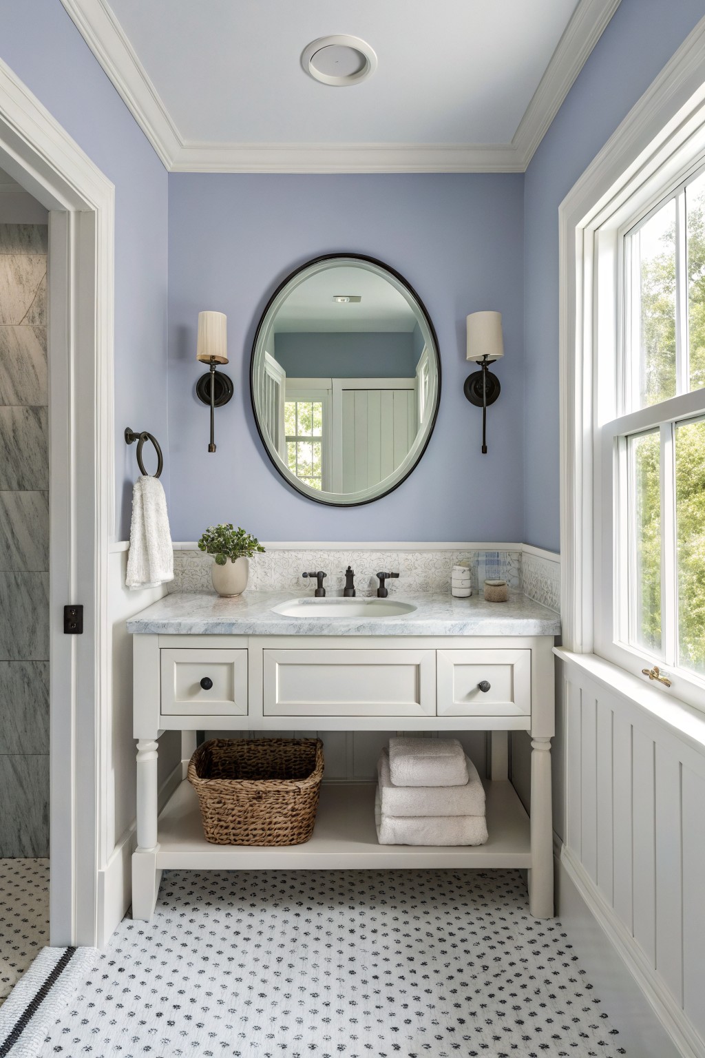 A stylish bathroom with a light blue wall, marble sink, and elegant fixtures.
