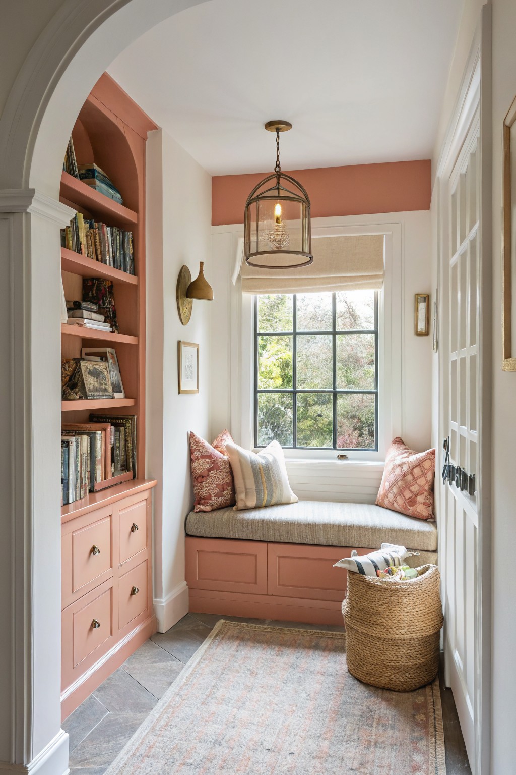 Cozy nook with pink shelving, a cushioned bench, and a woven basket.
