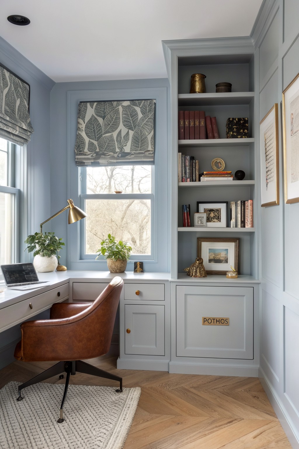 A home office with soft blue-gray walls and built-in bookshelves around a window.