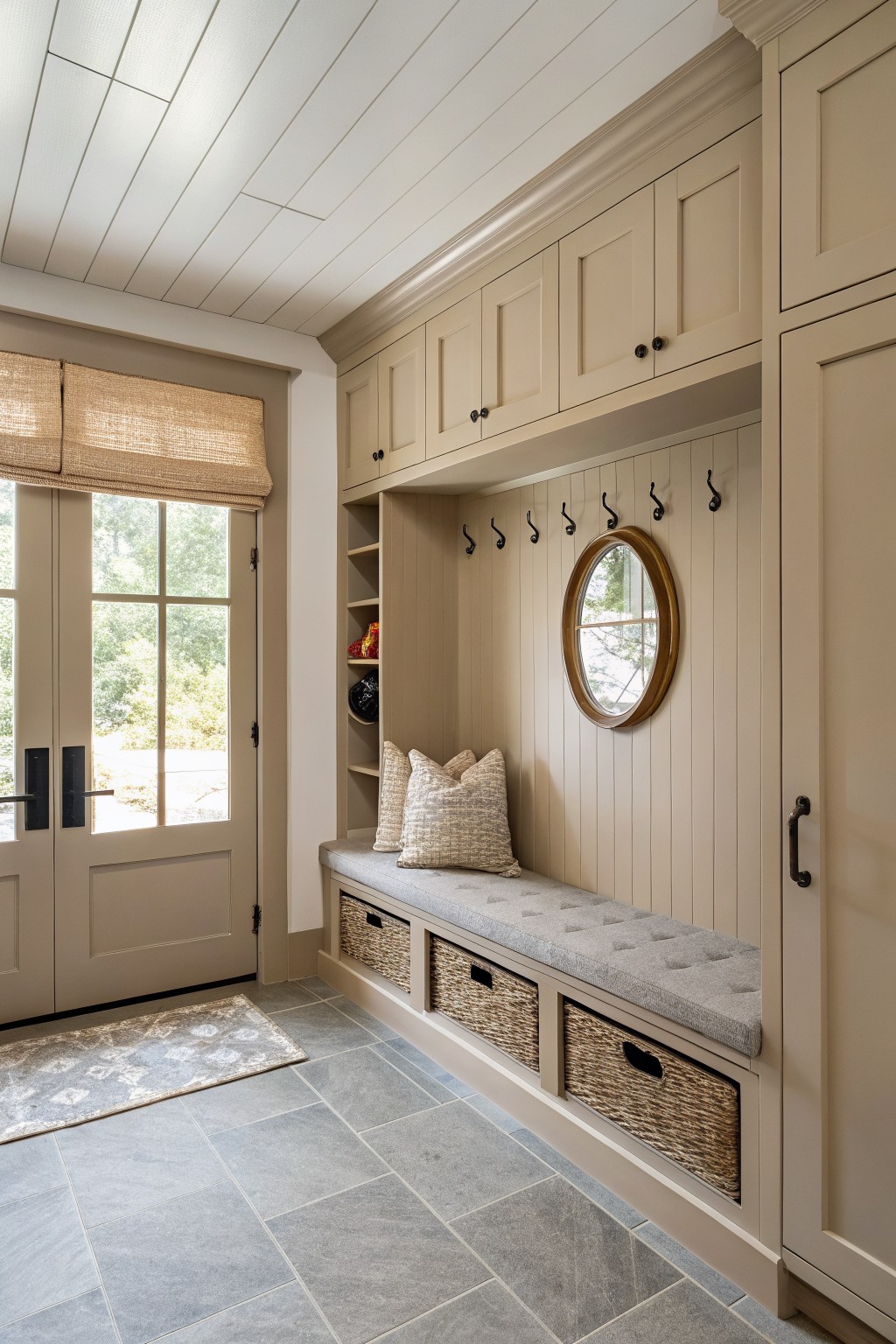 Built-in bench and cabinetry painted in a soft greige neutral in a modern entry area.