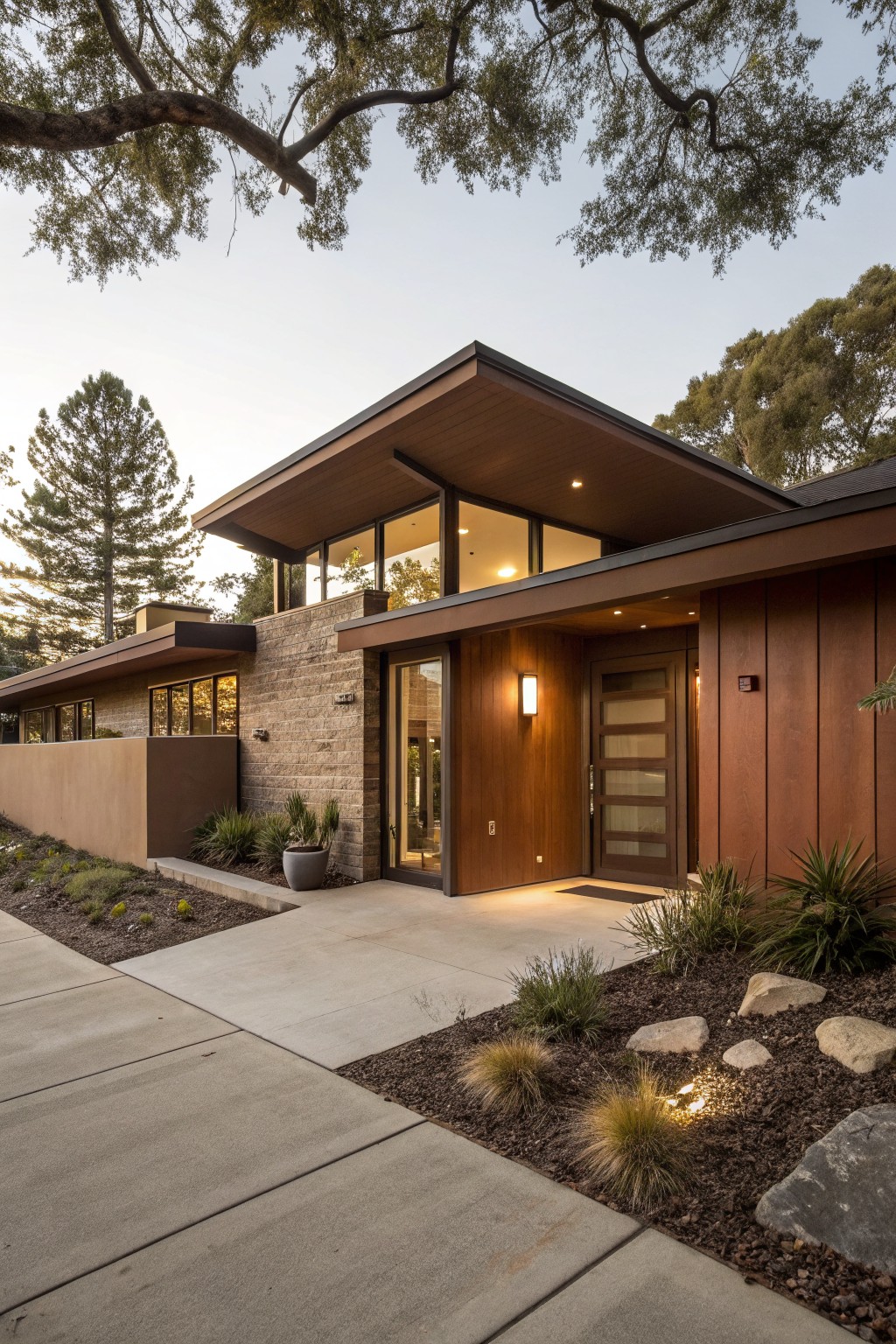 A modern home exterior finished in warm brown wood siding beside a stone wall.