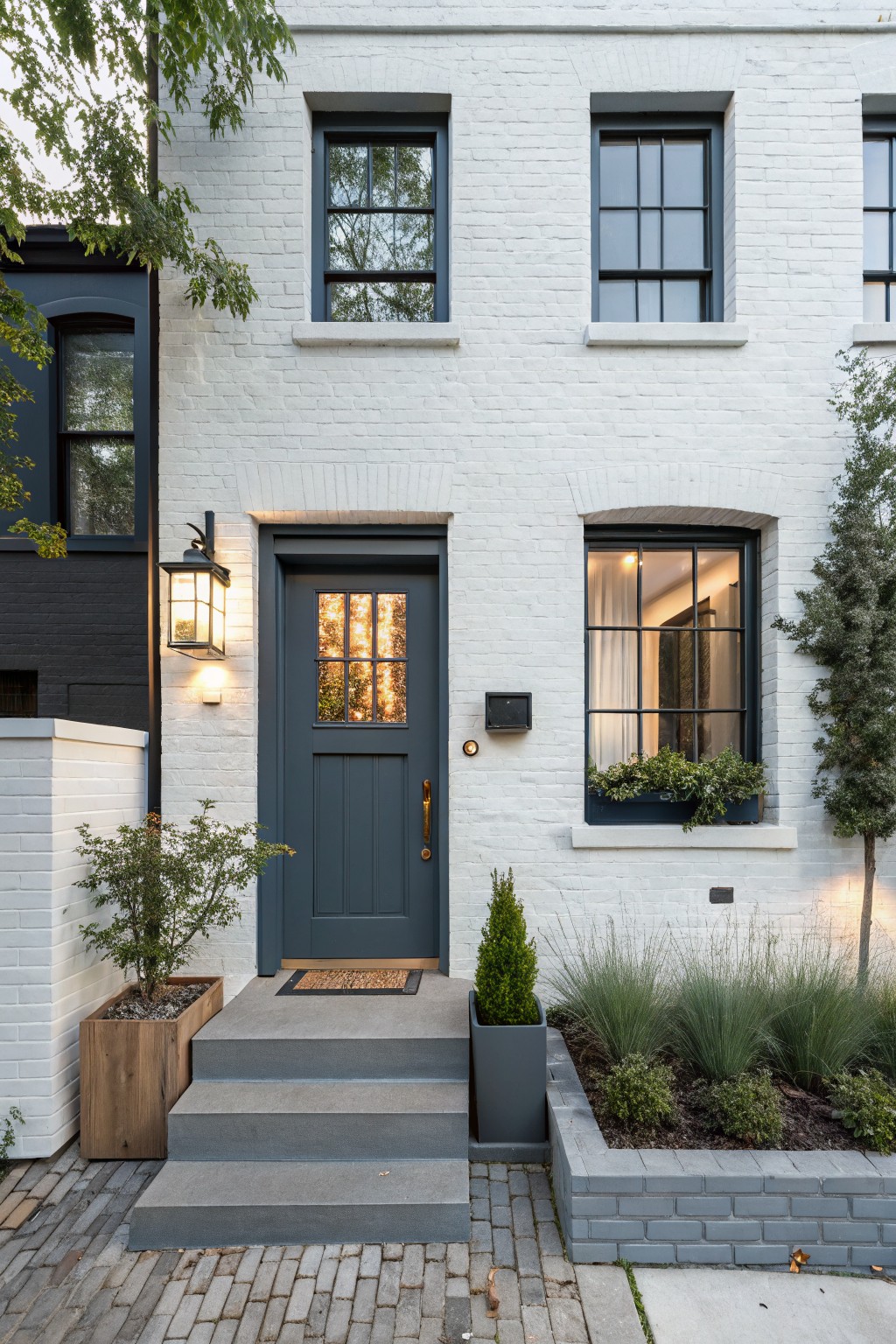 White brick exterior with dark trim and windows on a house facade.
