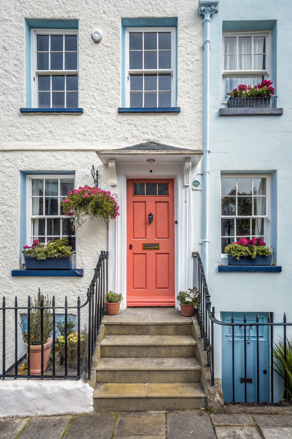 White exterior walls with blue trim on a house front.