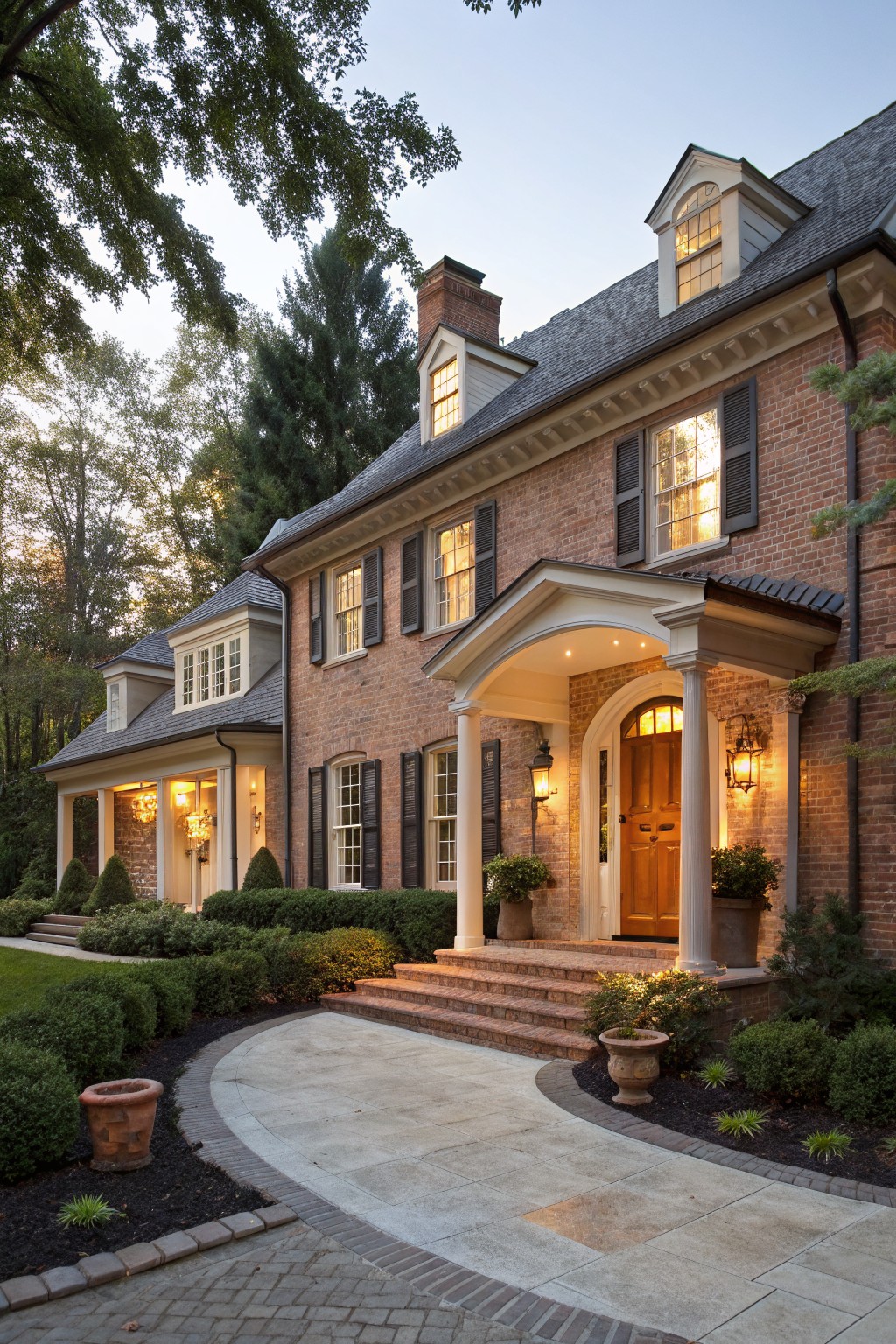 Brick house exterior with warm white painted trim and columns around the front entrance.