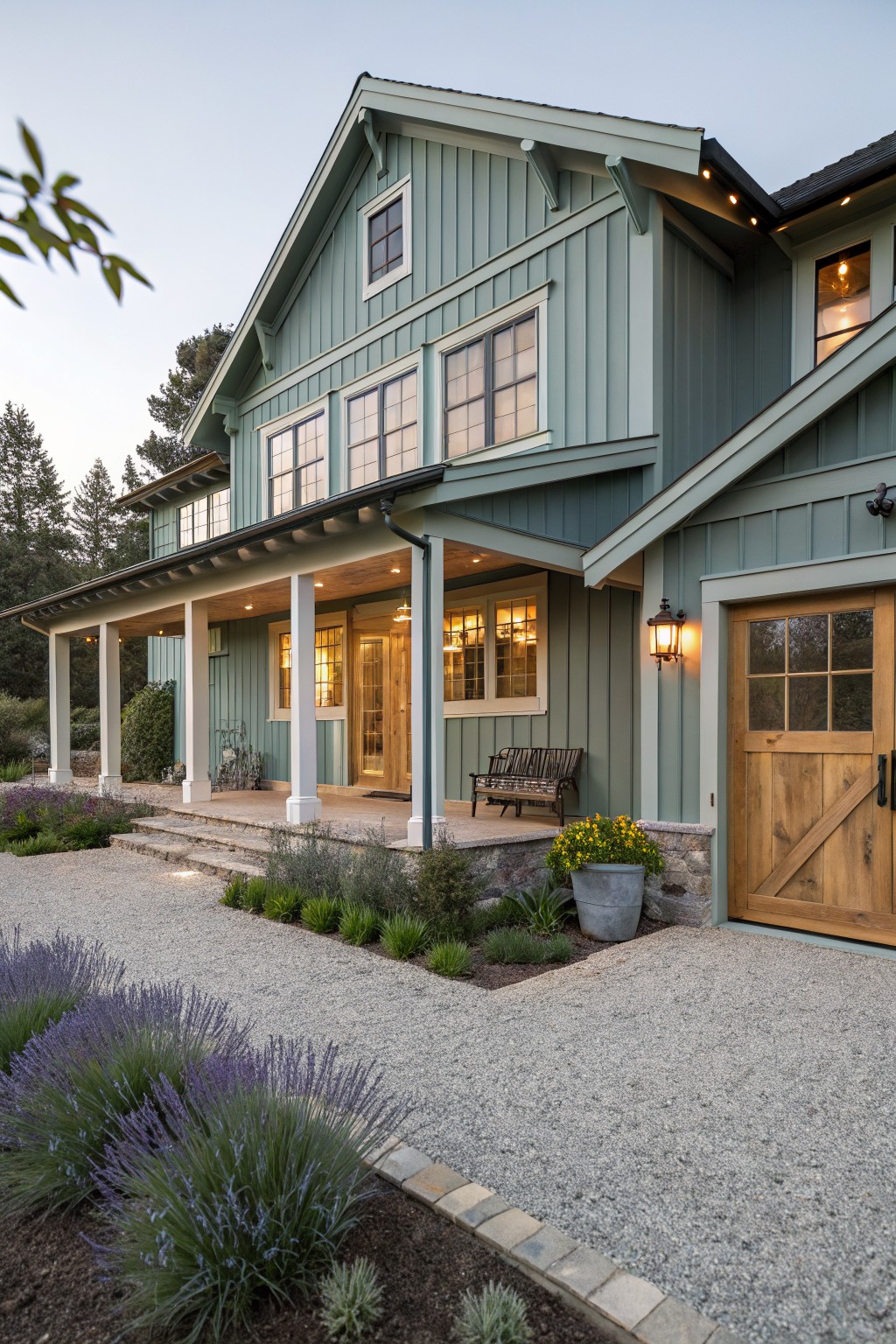 Two-story green house with a wooden door, gravel pathway, and lavender plants.