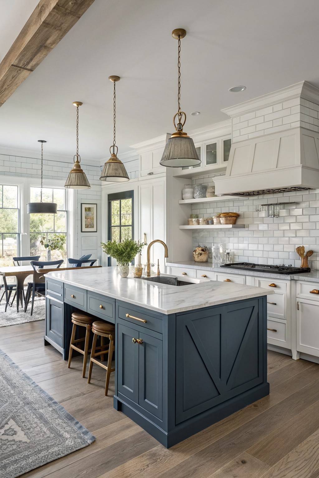 A kitchen island painted deep navy blue with white marble countertops and brass hardware.