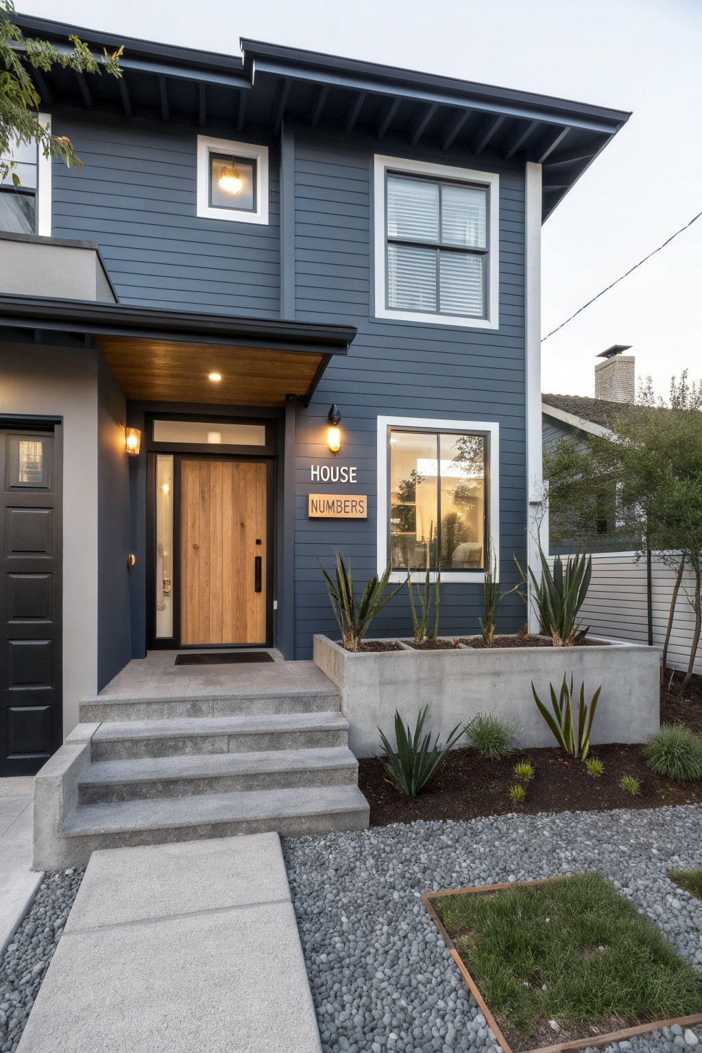A two-story house with deep blue gray siding and white window trim.