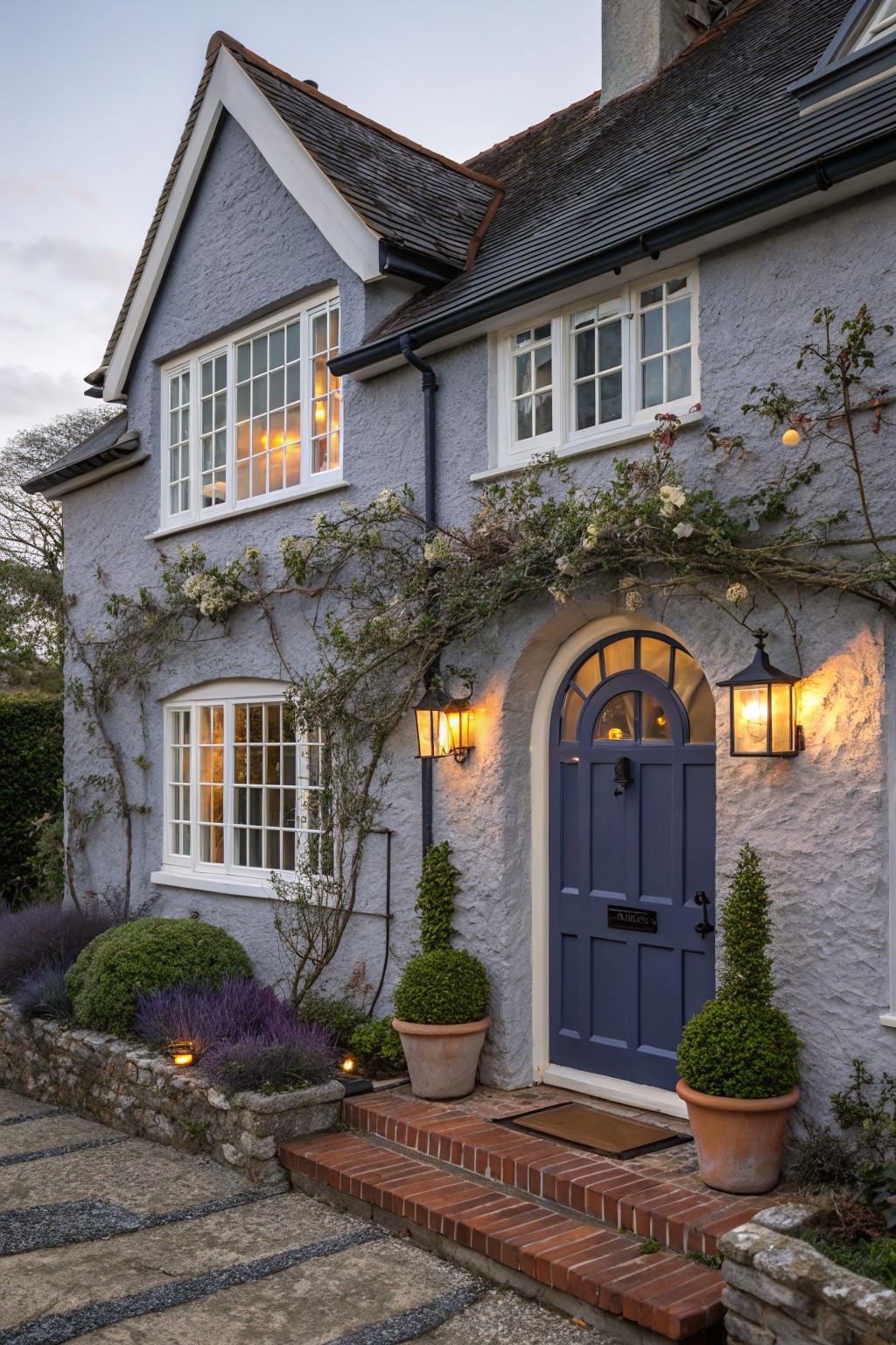 A house exterior painted in a soft blue gray with white window trim.