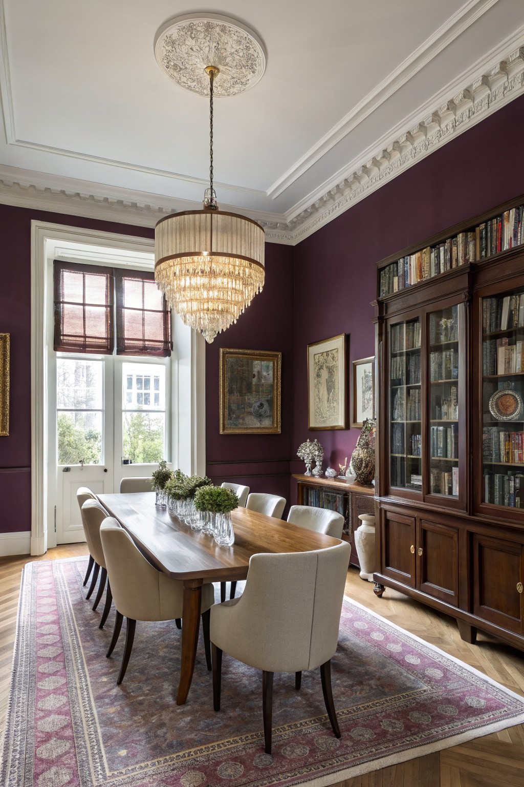 Deep plum walls in a dining room with white trim and dark wood built-ins.