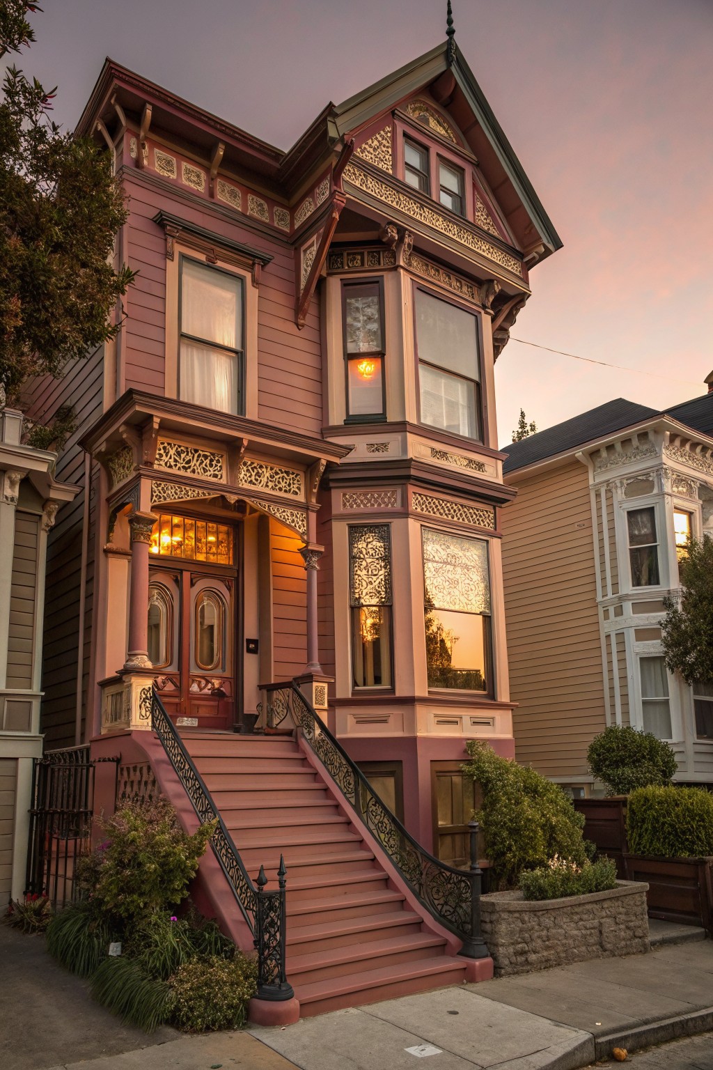 A Victorian house with soft dusty rose exterior siding.