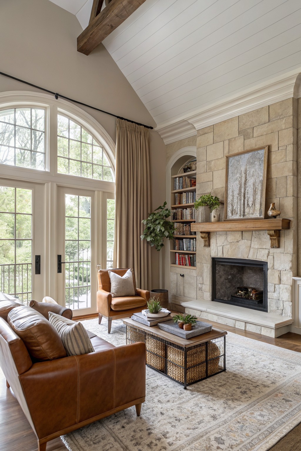 A living room with soft greige walls and a large stone fireplace.