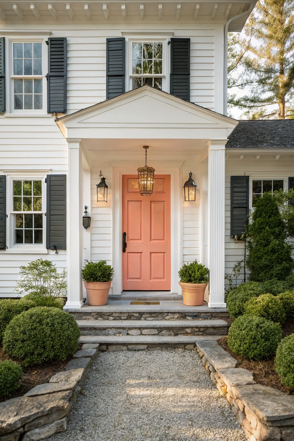 White house with a soft coral front door under a small portico.