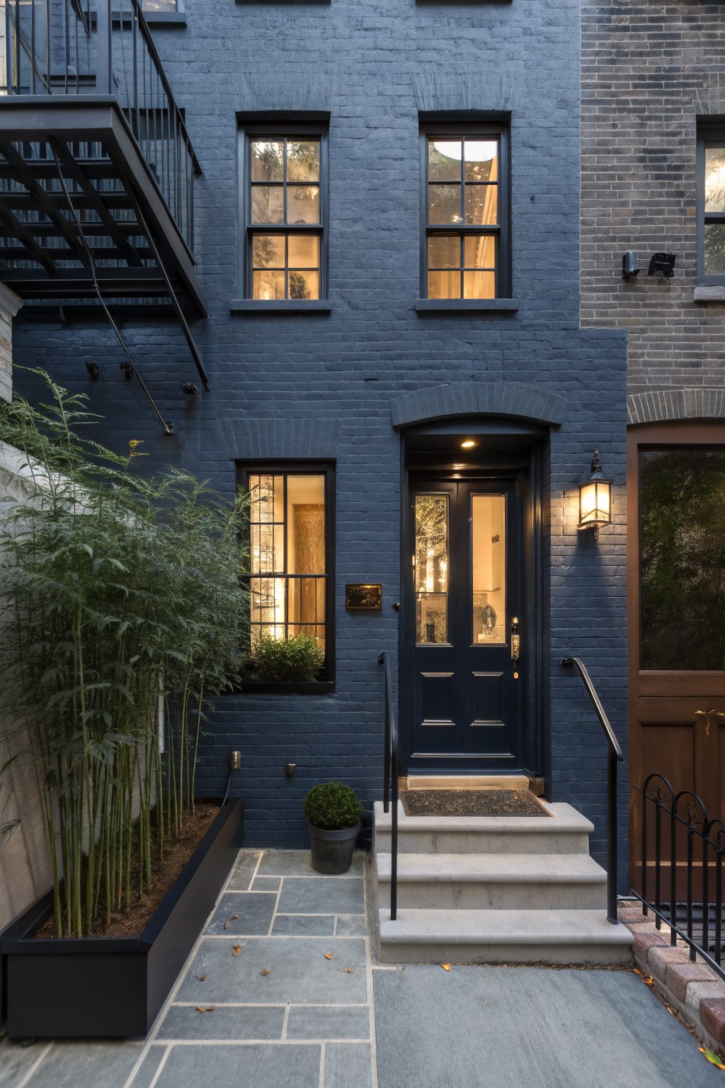 Dark navy blue painted brick exterior with a matching front door and stone steps.