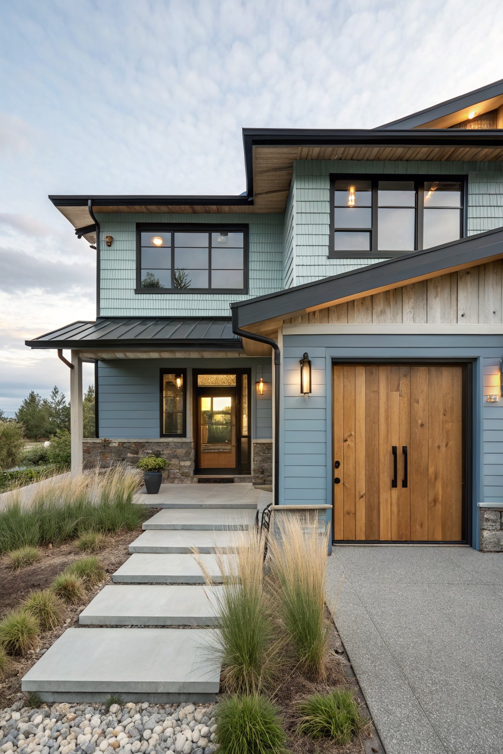 House exterior with soft blue-green siding and wood garage doors.
