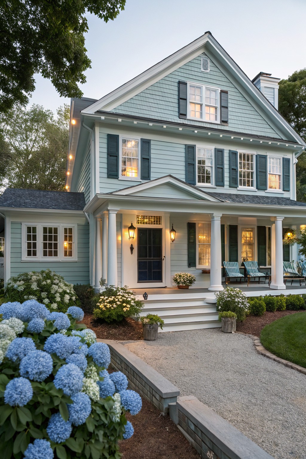 A two story house with soft blue green siding and white trim around the porch.