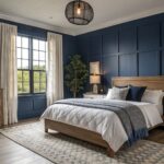 A bedroom featuring deep navy walls with white bedding and wood flooring.