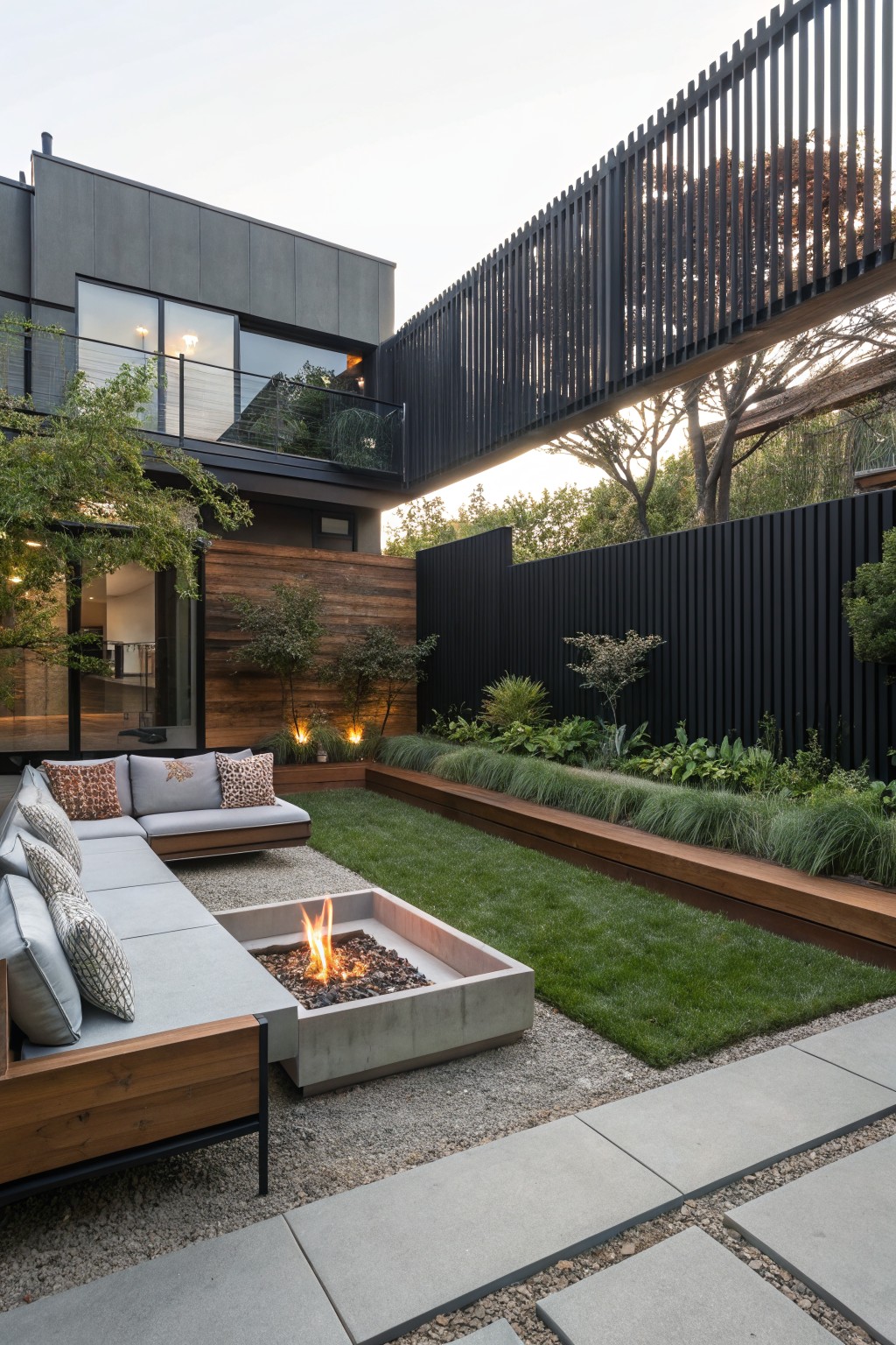 Modern courtyard with fire pit, gray sectional sofa, green lawn and slatted bridge