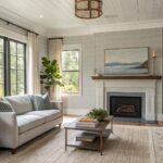 Cozy living room with cream sofa, stone fireplace, potted tree, and jute rug.