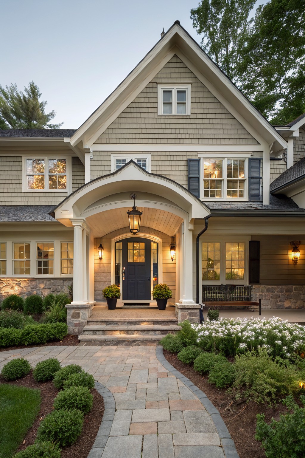 A house exterior painted in soft gray siding with white trim and stone accents.