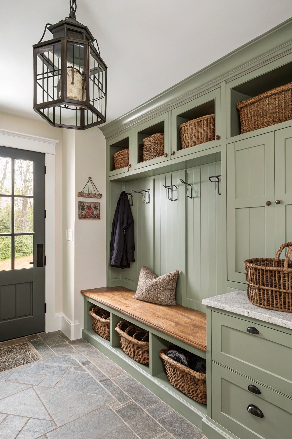 Mudroom with soft sage green built-in cabinetry and bench.