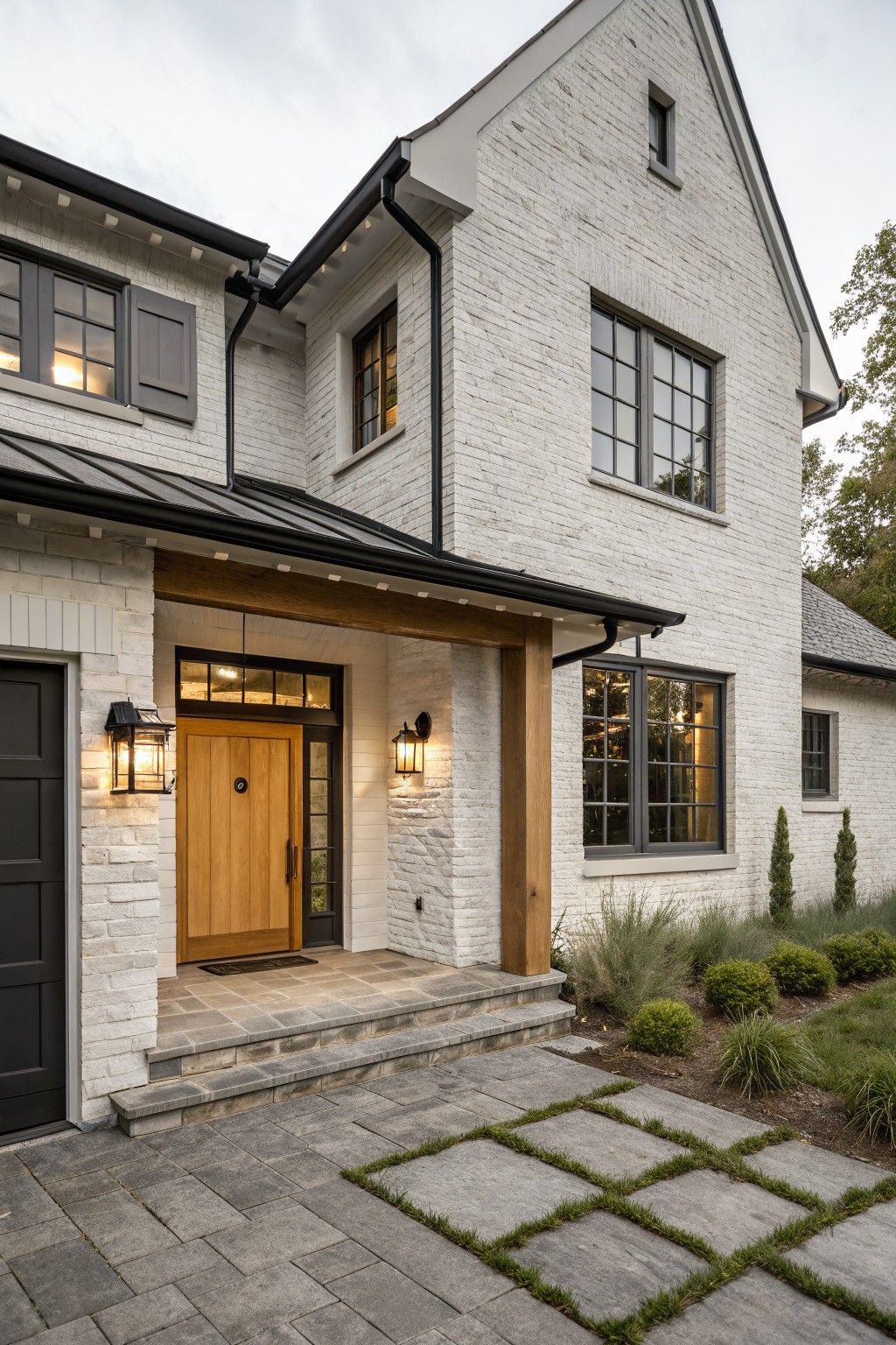White painted brick on a farmhouse exterior with black windows and wood trim.