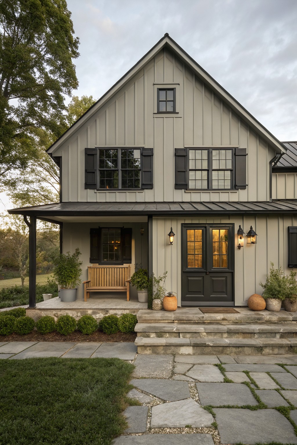 A modern farmhouse with soft sage green siding and black trim.
