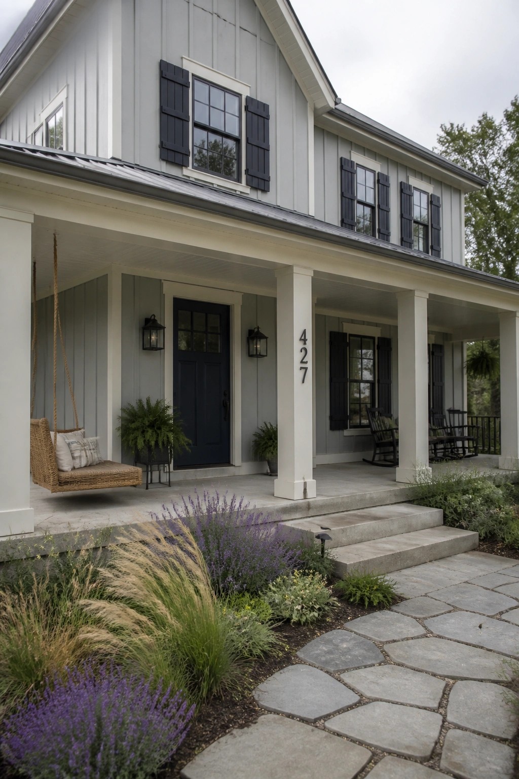Farmhouse exterior with light blue gray siding and white trim.