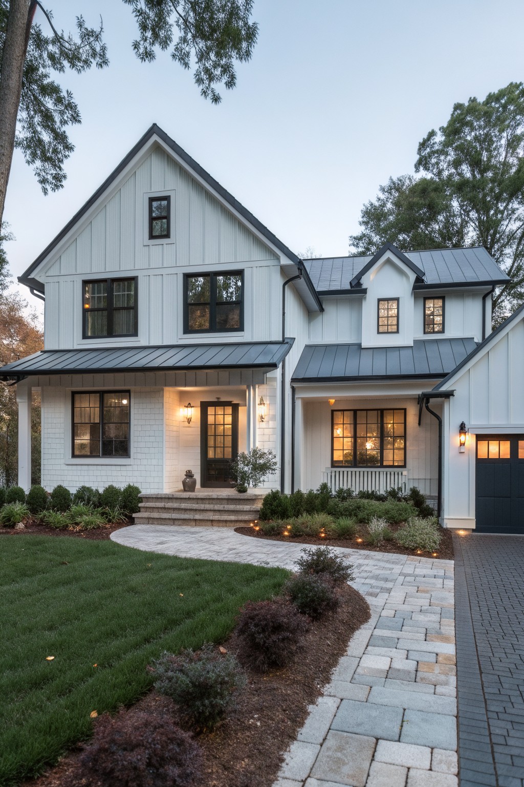 White farmhouse siding with a dark metal roof and black window frames.