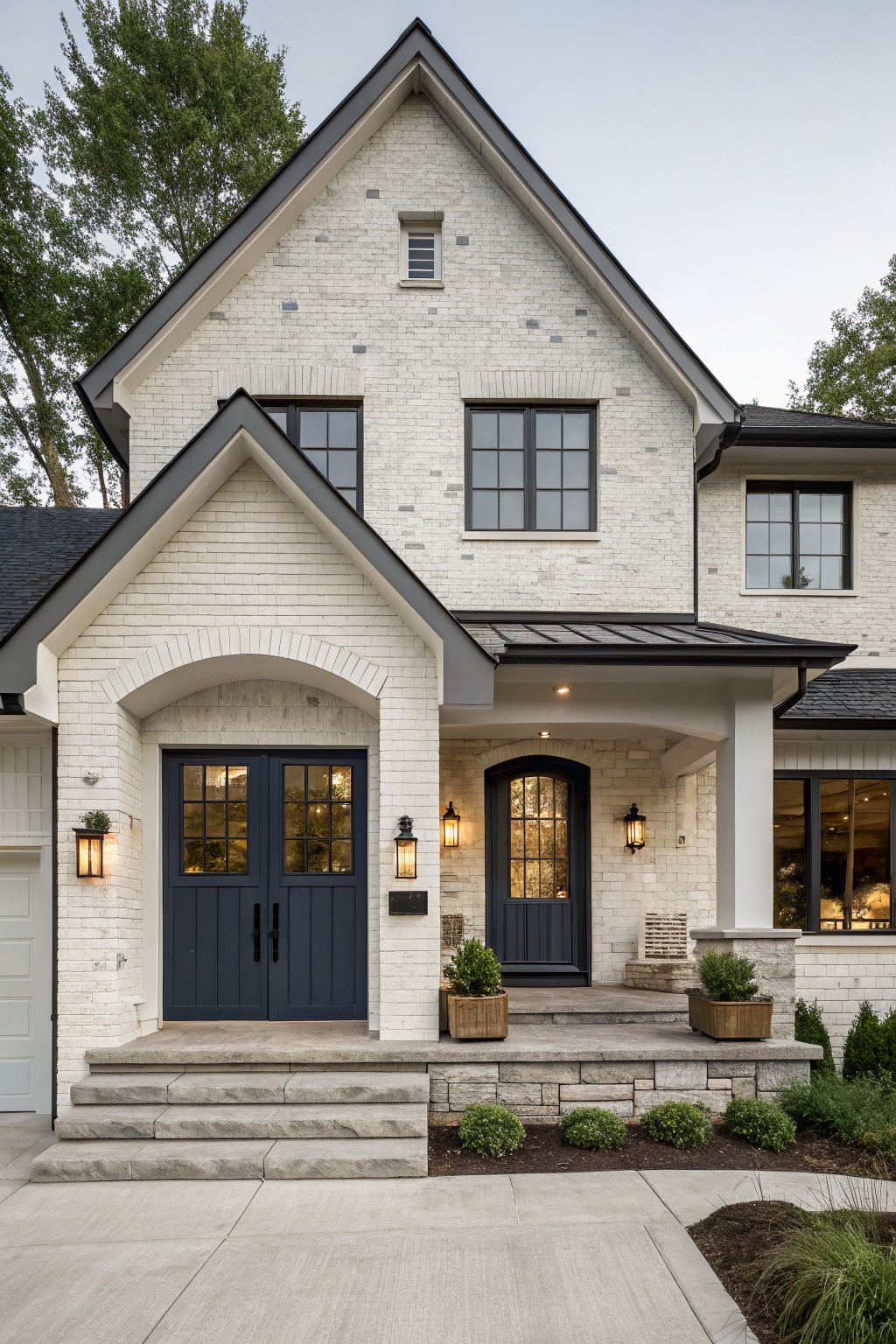 White brick house with navy double doors, arched porch, and black-framed windows