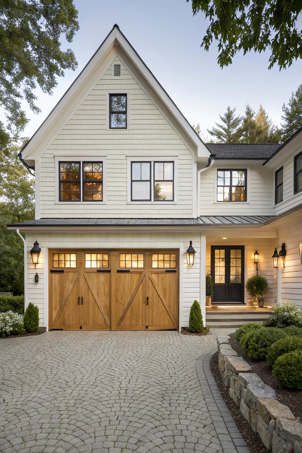 Light warm white siding on a two-story farmhouse with wood garage doors.
