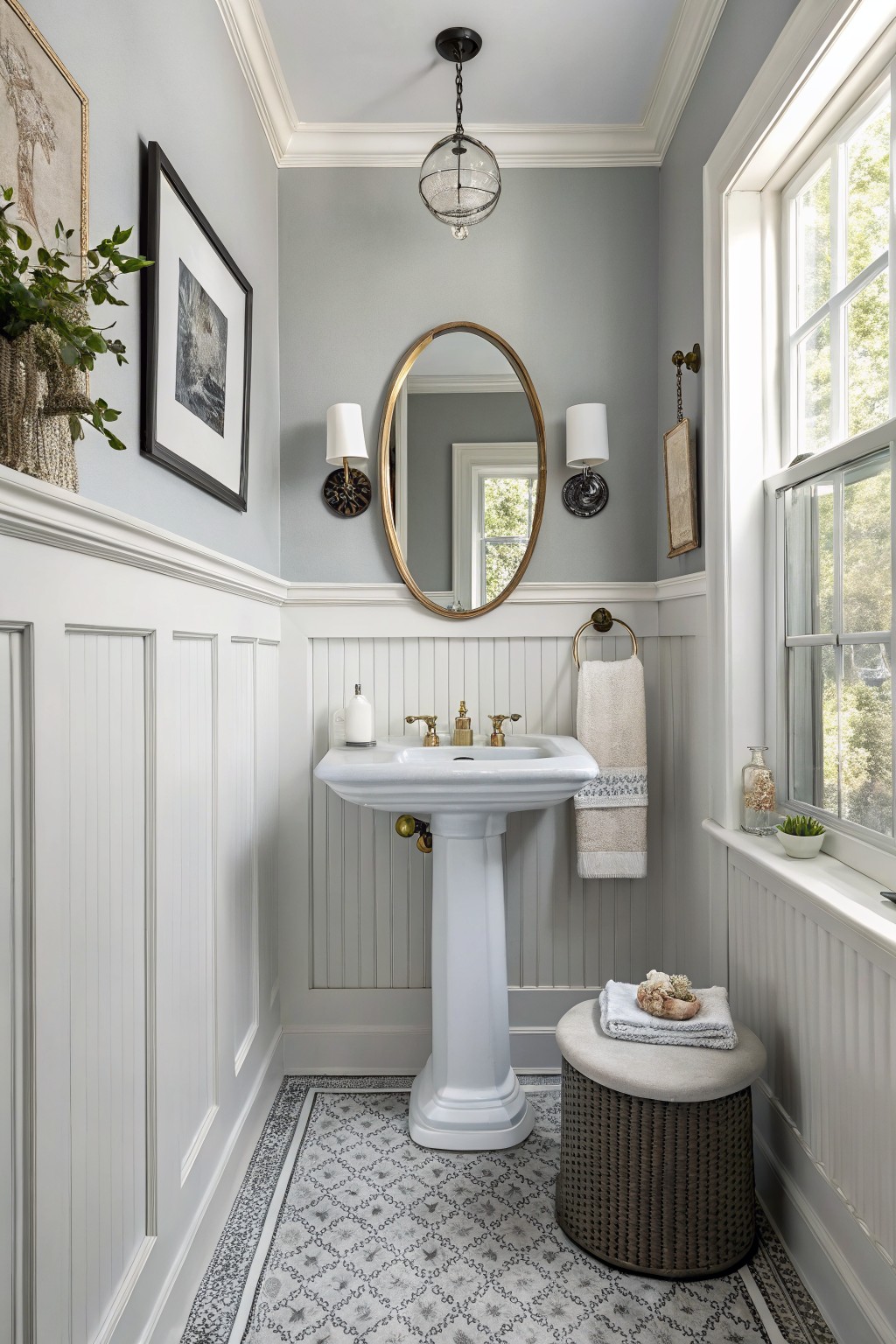 A small bathroom with soft blue gray walls above white beadboard wainscoting.