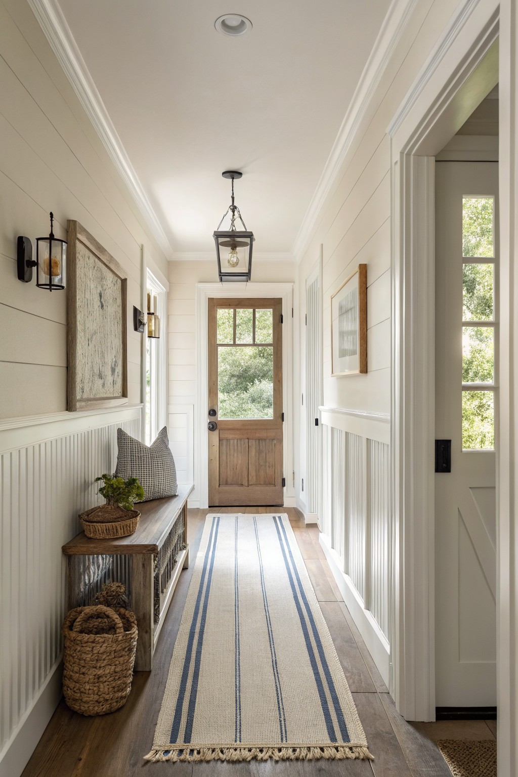 A narrow hallway with walls painted in a soft creamy white.