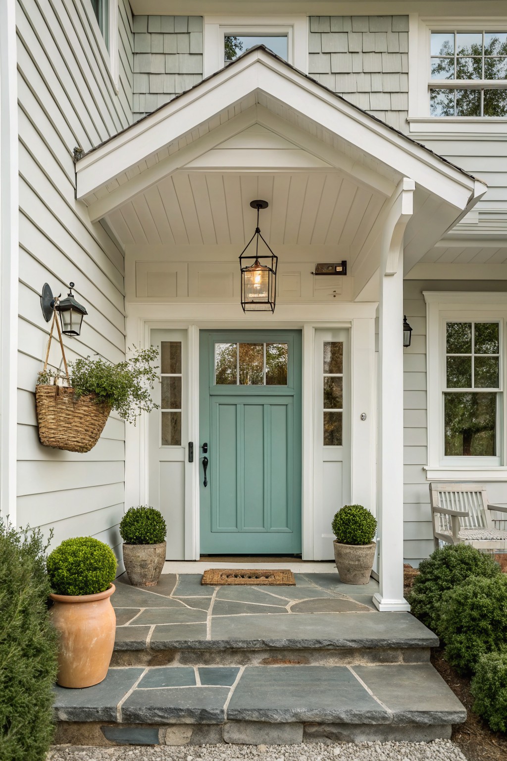 A soft teal green front door on a white farmhouse exterior.