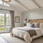 A bedroom with light greige walls and wood furniture.