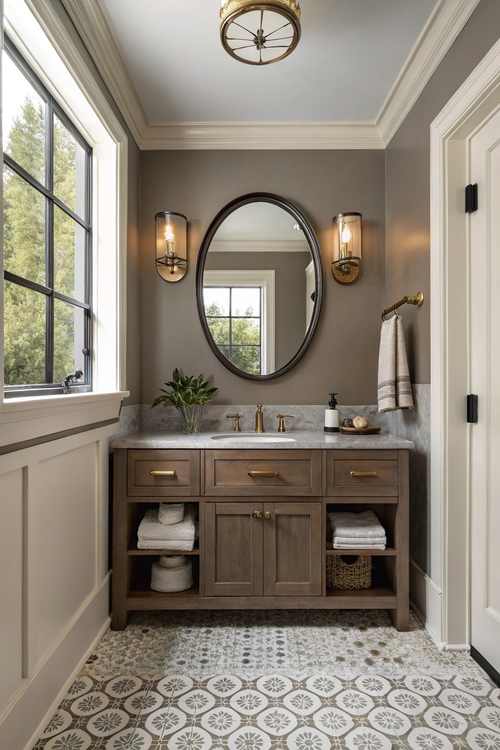 Elegant bathroom with wooden vanity, marble countertop, oval mirror, and patterned tile floor.