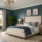 A bedroom with deep teal walls and a large upholstered bed.