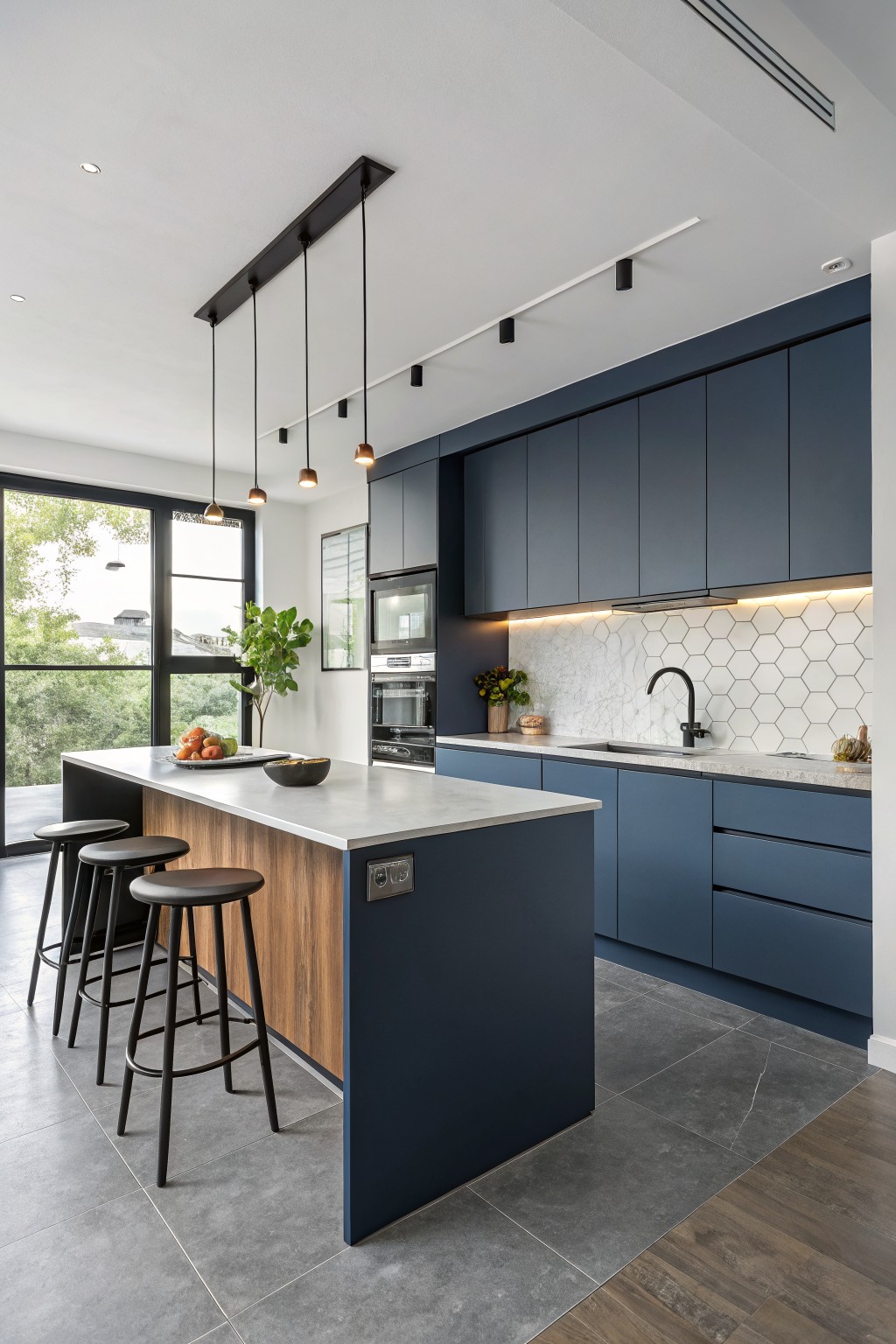 A kitchen with deep navy blue cabinets and a wood island.