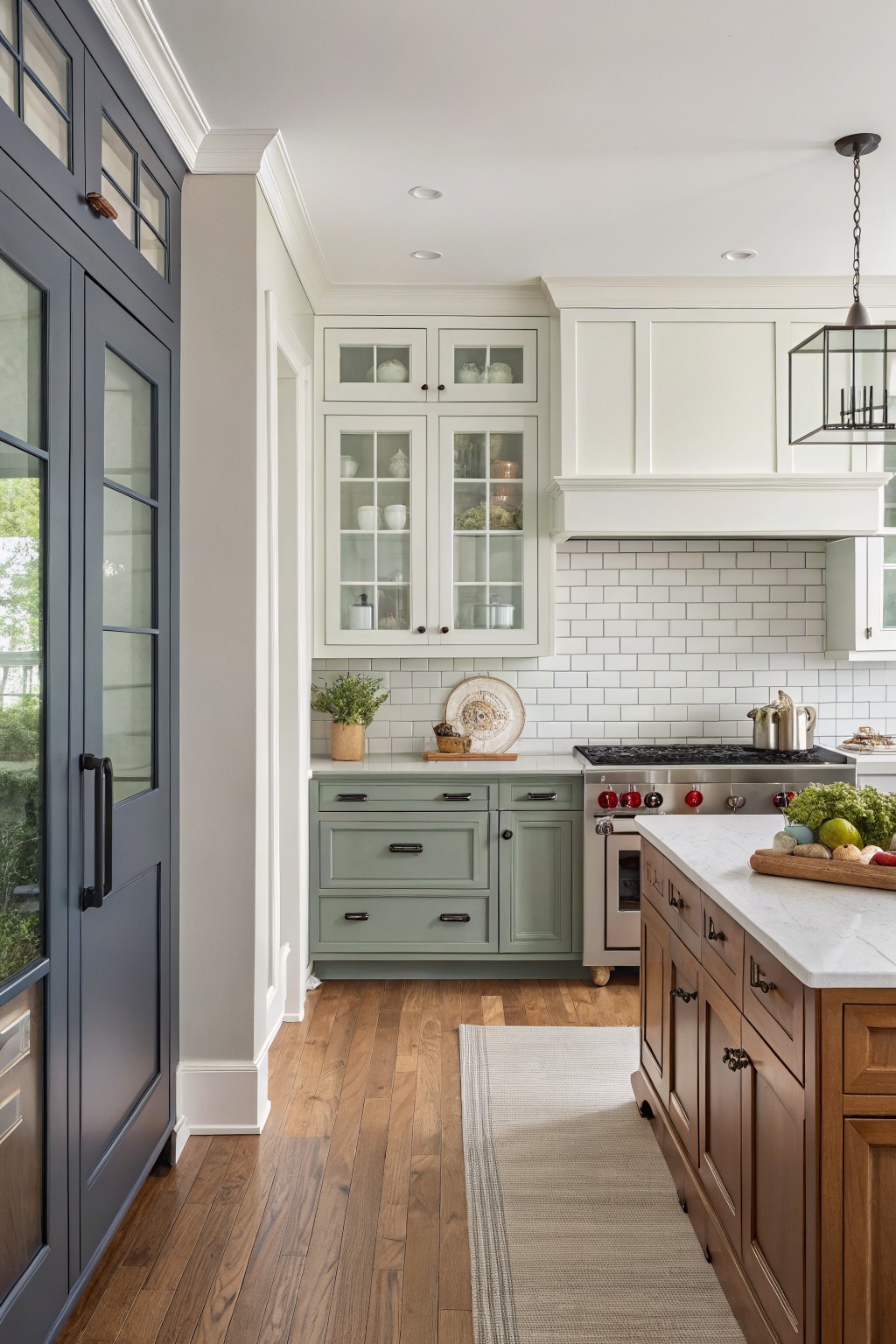 Kitchen with sage green cabinets, white subway tiles, wooden island, and hardwood floors