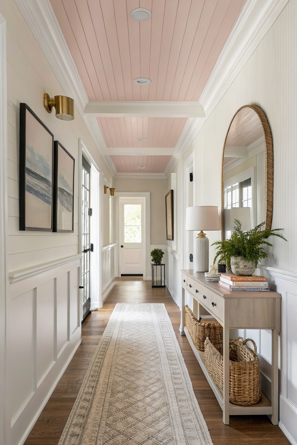 A hallway with a soft pink ceiling and white walls.