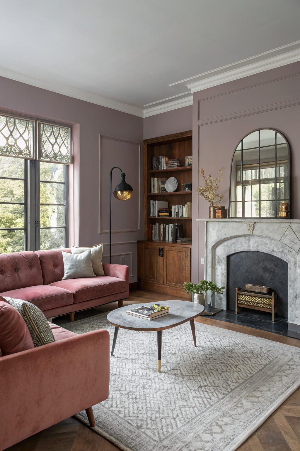 Living room walls painted in a soft dusty pink with built-in wood shelving.