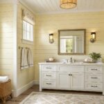 Bathroom walls painted in a soft warm yellow with white trim and a marble vanity.