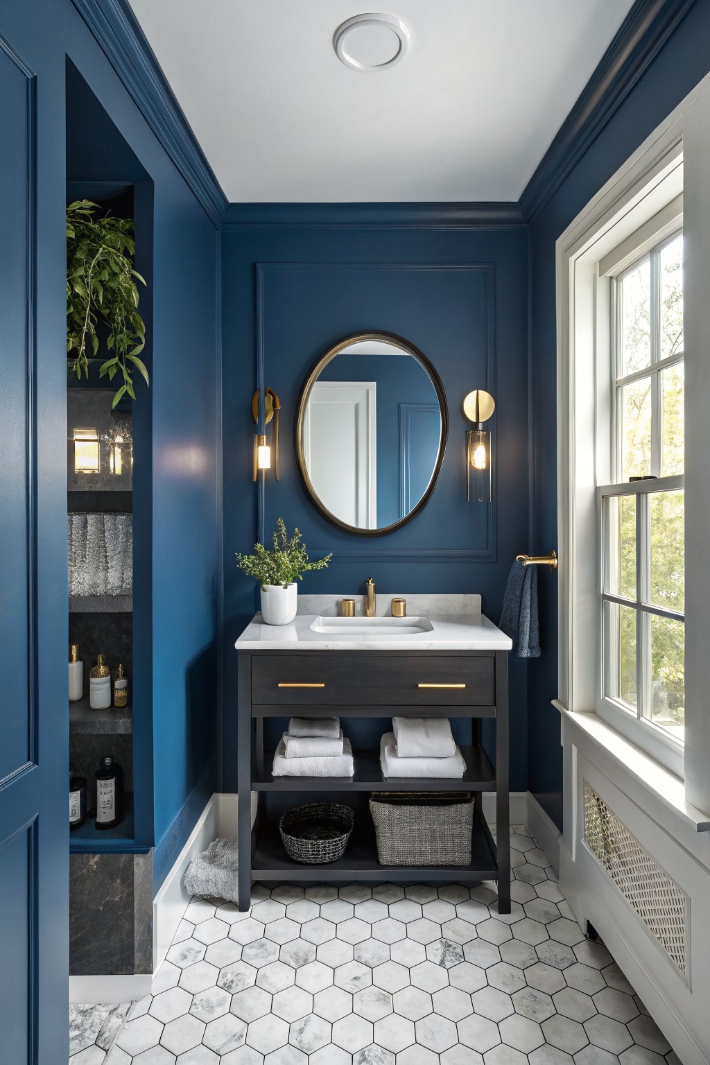 Bathroom walls painted in a deep navy blue with a white marble vanity.