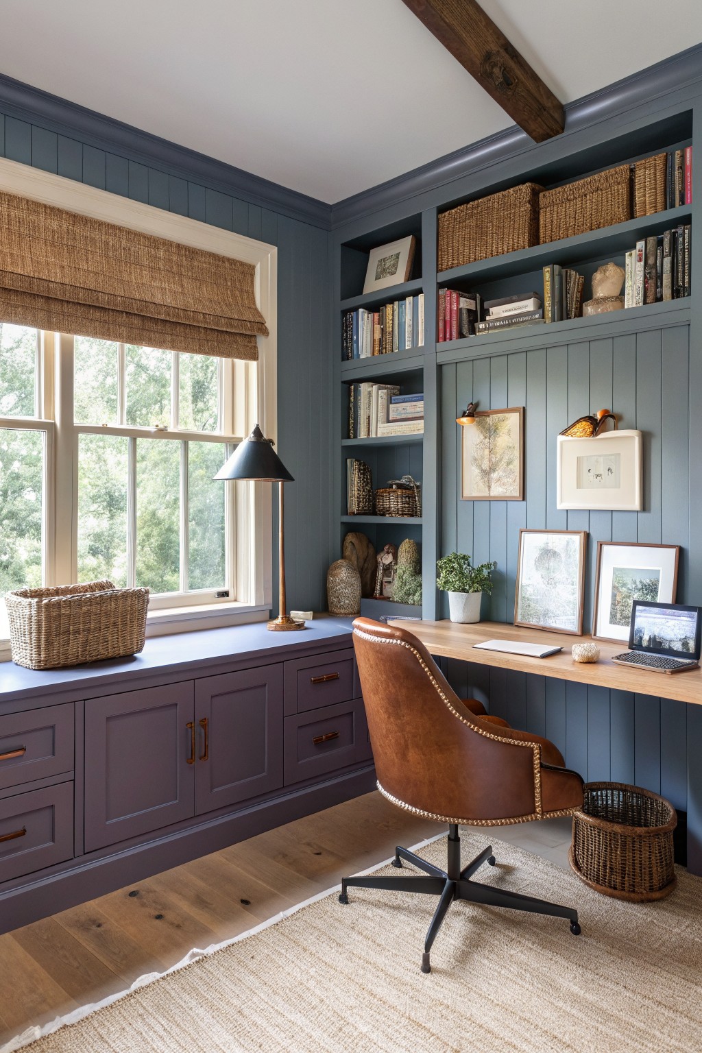 A home office with muted blue-gray walls and built-in bookshelves.