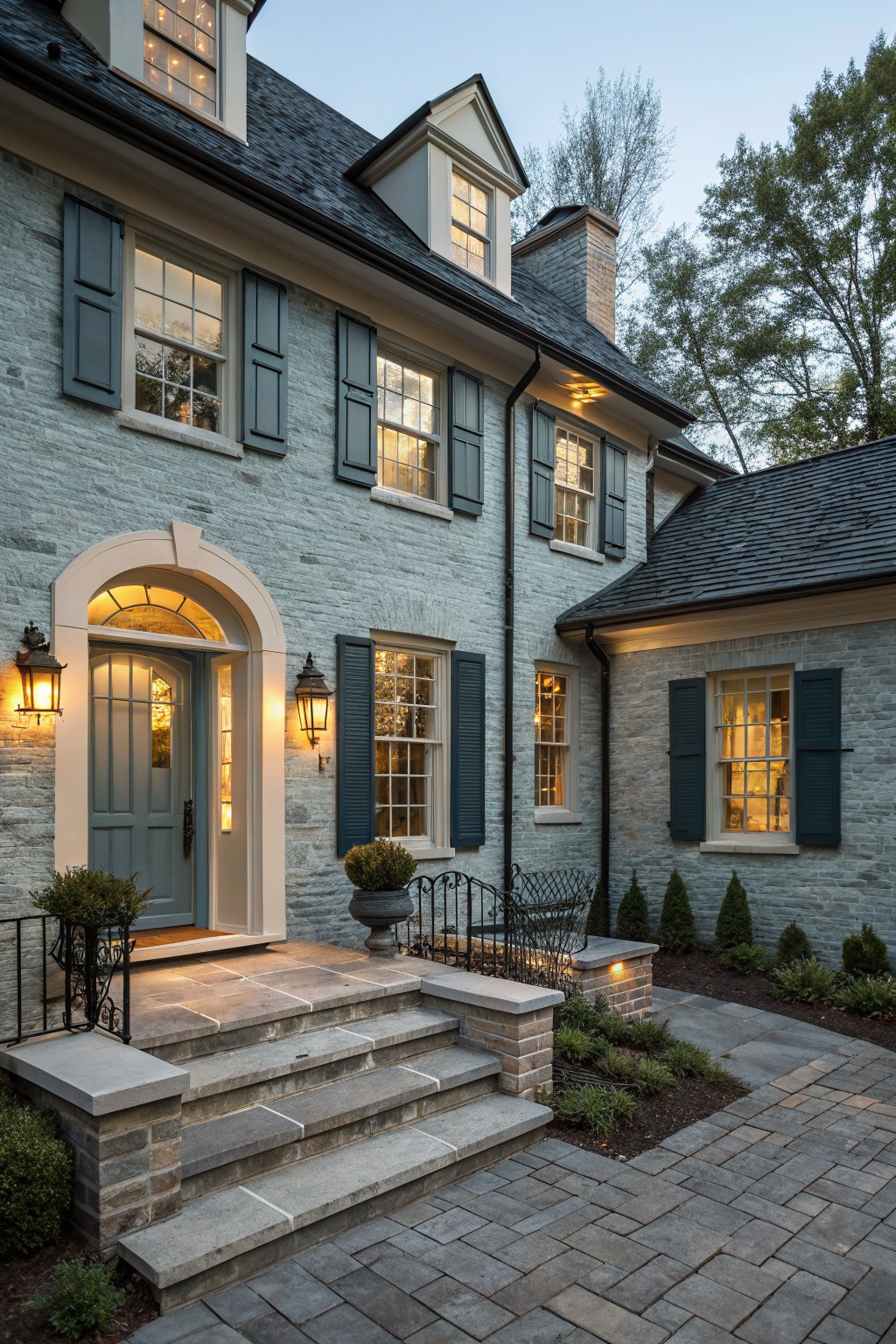A house exterior painted in soft blue gray stone with dark shutters and steps.