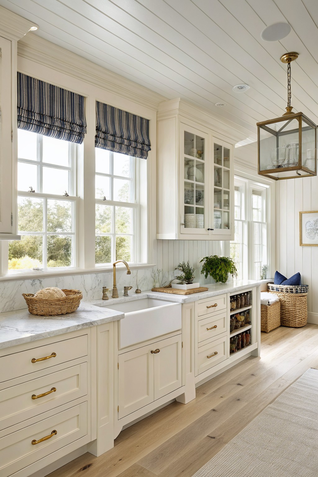 Creamy white cabinets in a kitchen with a farmhouse sink and marble counters.